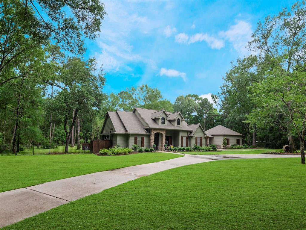 This picturesque home features a spacious, well-maintained lawn surrounded by mature trees, offering privacy and a serene setting. The house boasts a charming blend of stone and siding with a welcoming front entrance and a long, circular driveway. Ideal for those seeking a tranquil, nature-filled environment.