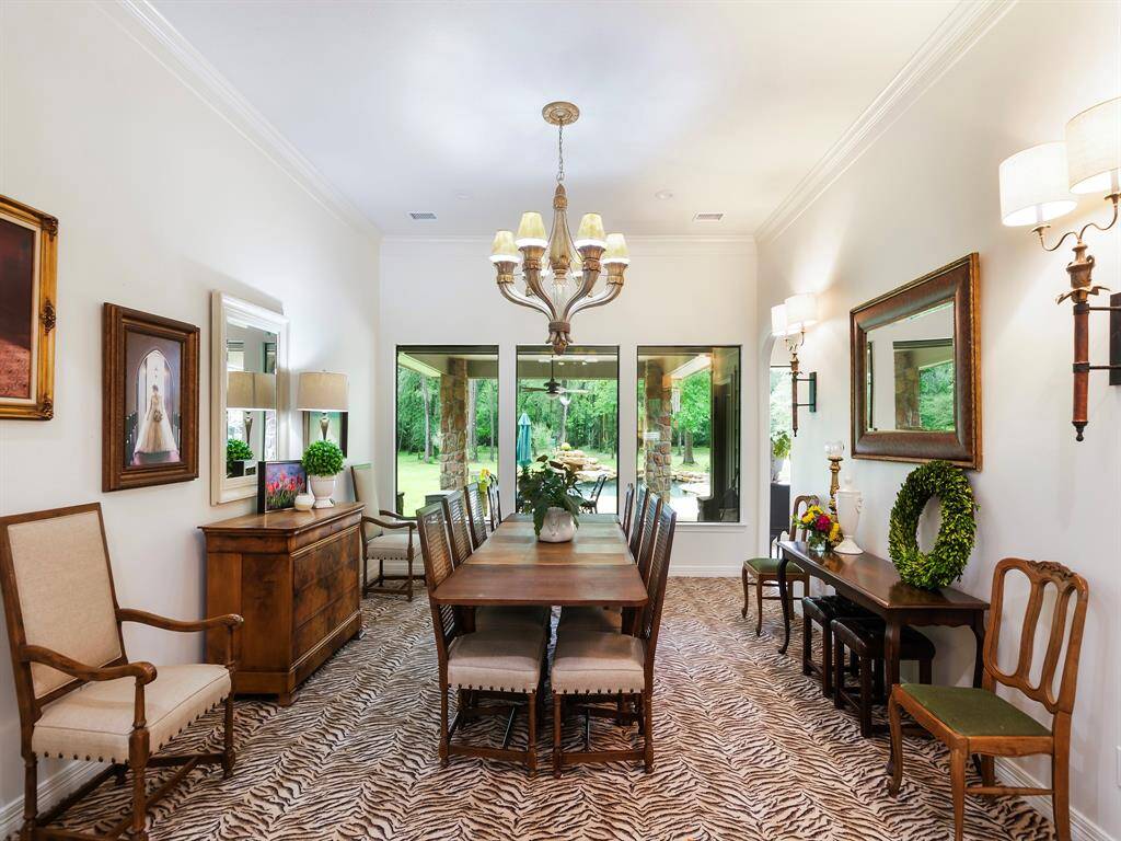 This formal dining room is perfect for large family gatherings, offering ample space and a big open view overlooking the pool and the acreage.