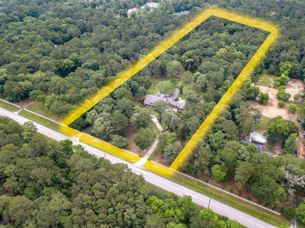 This aerial view captures the full expanse of the beautifully maintained 5-acre property, showcasing the home, surrounding trees, open green space and the peaceful privacy of this exceptional setting.