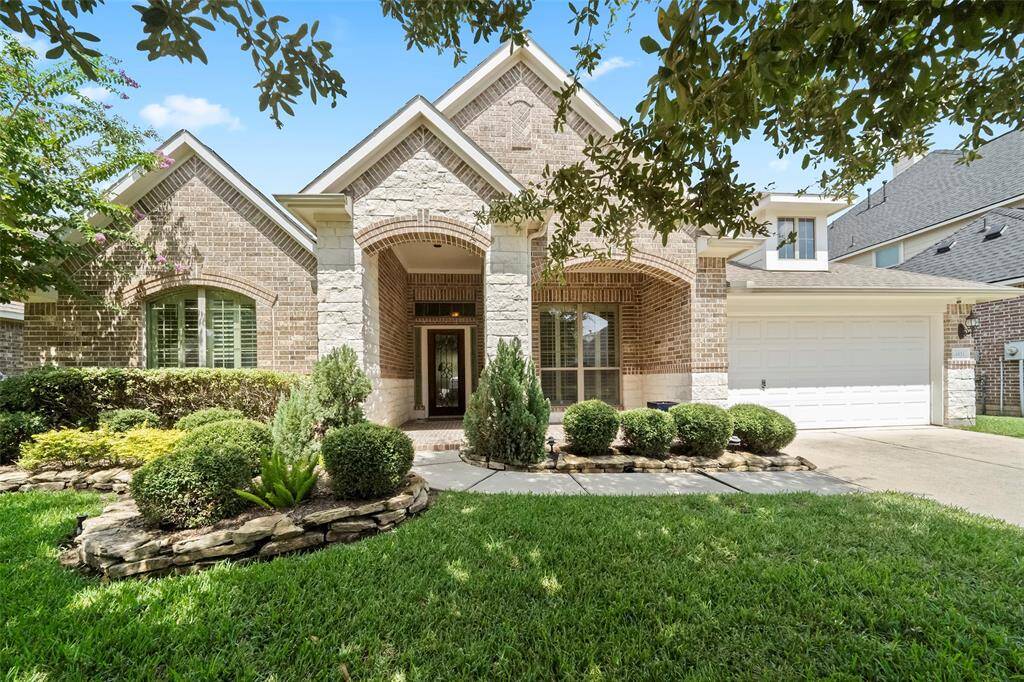 Close-up of the stately front elevation showcasing elegant stone archways, brick detailing, and a grand covered entryway that welcomes guests with timeless elegance.