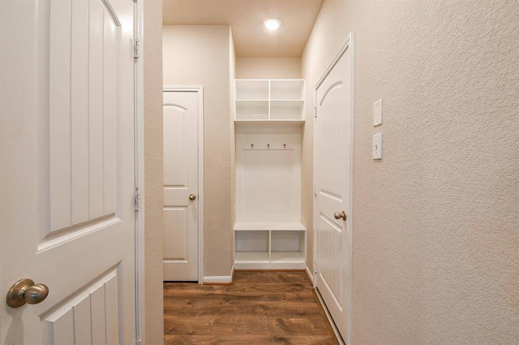 This mud room is nicely placed for first floor comings and goings, in this lovely view of the front entry, from the inside, and to the front room, behind french doors, right.