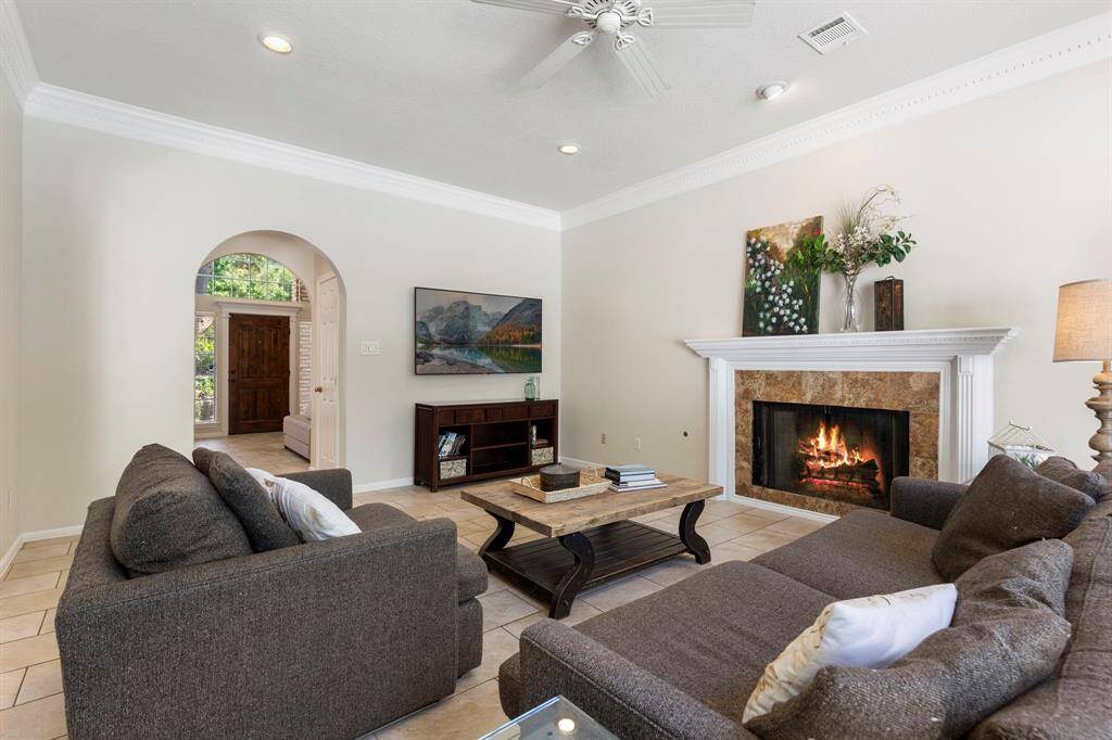This space includes tile flooring and a cozy gas log fireplace with tile surround and mantel.