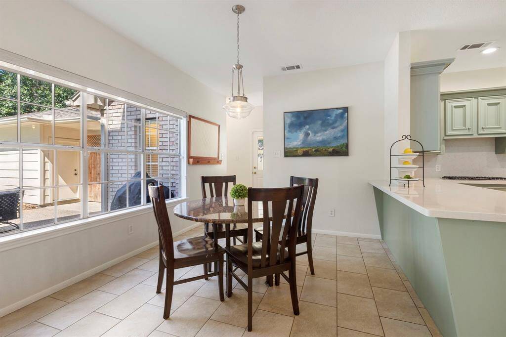 The breakfast room is filled with natural light from an oversized window that offers a beautiful view—an ideal spot to enjoy your morning coffee. This inviting space flows seamlessly into the recently remodeled kitchen, where style meets functionality.