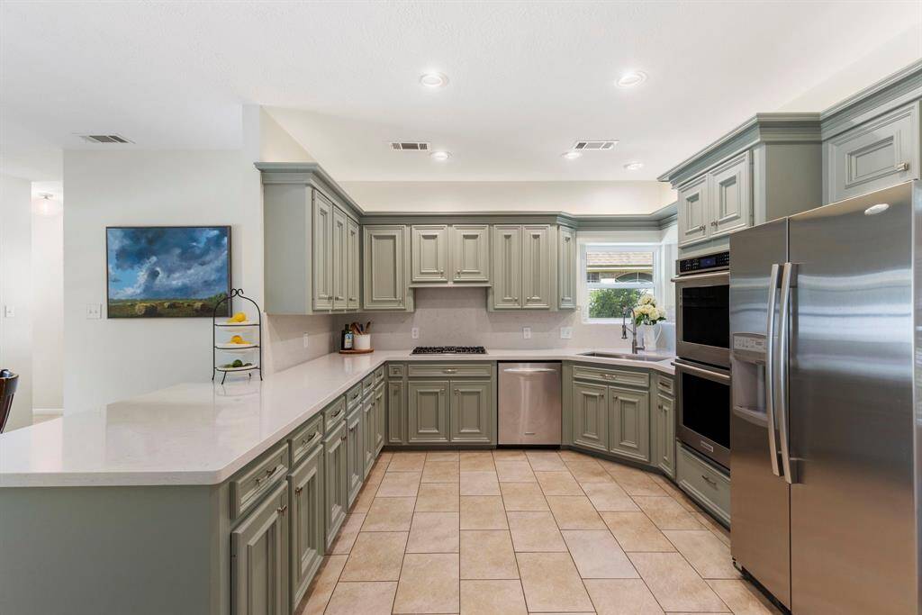 The kitchen is equipped with Kitchen Aid stainless steel appliances including dishwasher, double ovens and  new 4 burner gas cooktop.