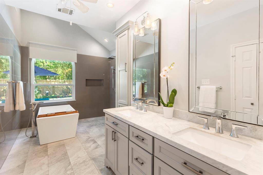 The luxurious ensuite bath has been thoughtfully renovated with Carrara marble countertops, dual undermount sinks, brushed chrome fixtures, and contemporary lighting, fixtures and mirrors. The cabinetry is designed with convenience in mind, featuring built-in electrical outlets inside the drawers.