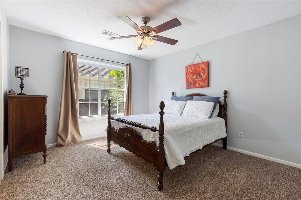 Secondary bedroom #1 offers a large window, walk-in closet with built ins and plush carpet.