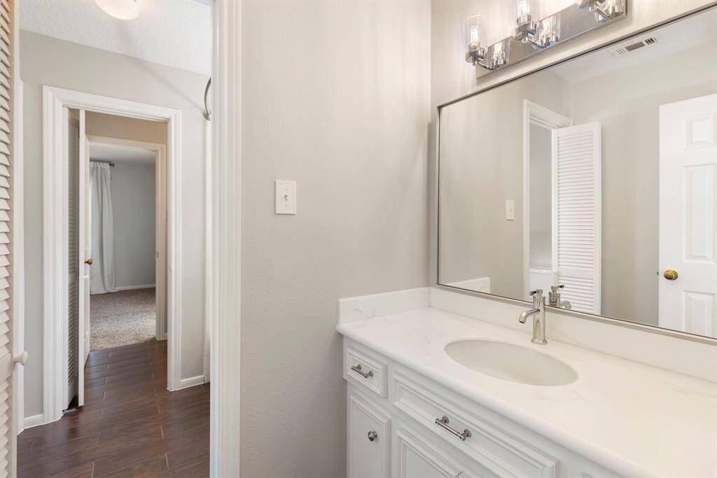 Secondary bedrooms #1 and #2 share a beautifully appointed Jack and Jill bath, complete with individual vanities featuring quartz countertops, bright white cabinetry, brushed chrome hardware and fixtures and updated modern lighting.