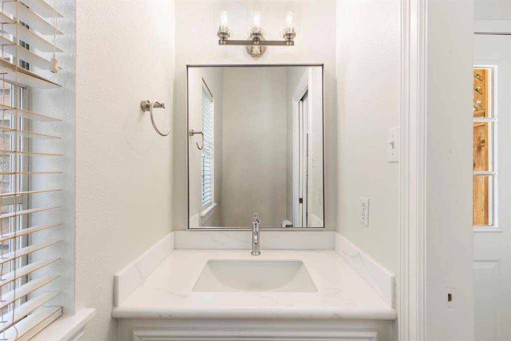 The remodeled half bath with Quartz counters and fixtures can be found just inside the back door - so convenient while enjoying the pool!