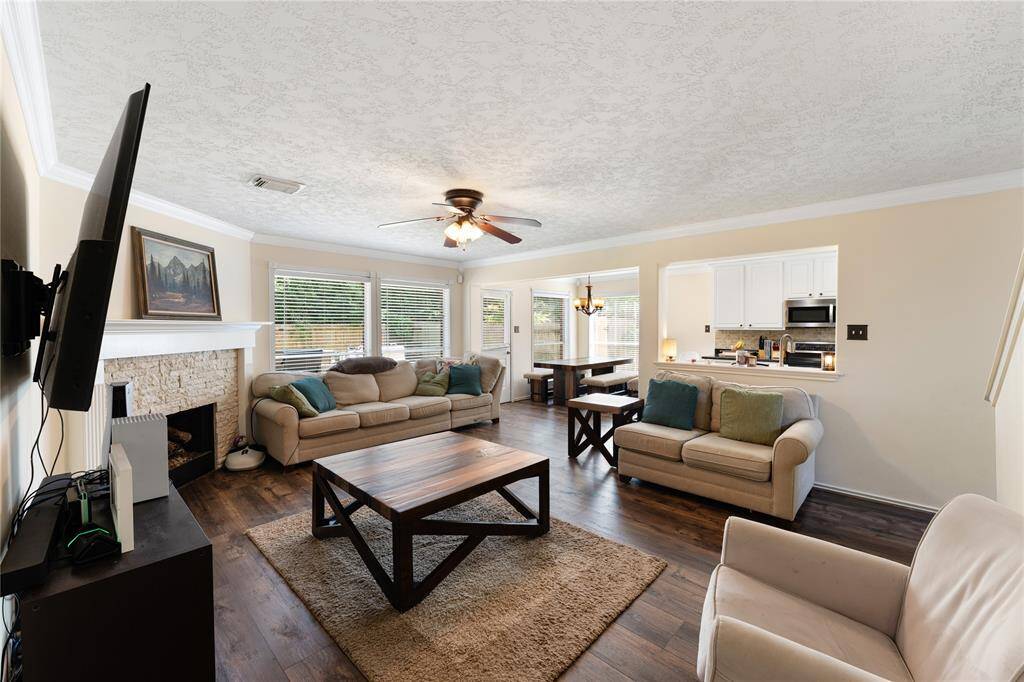 Bright dining area with large windows  and an elegant light fixture. It features a cozy bench-style dining set and opens to a comfortable living space.