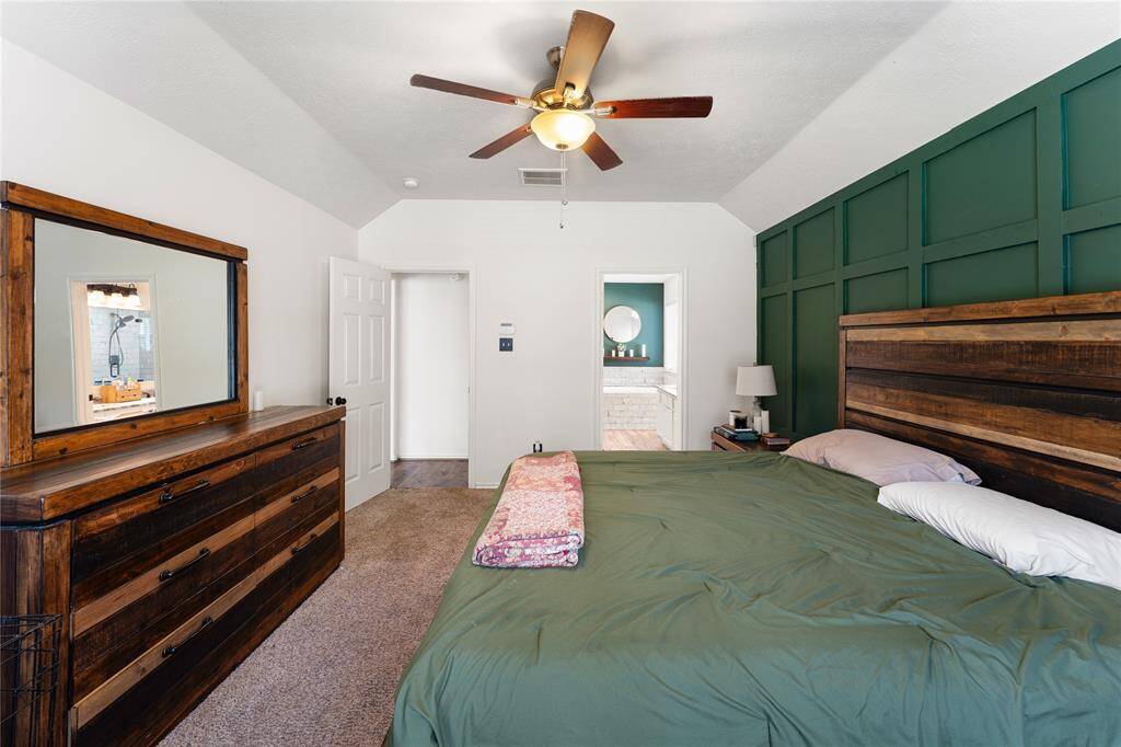Bright and inviting open-plan living area featuring ample room for large furniture, and a modern kitchen with stainless steel appliances. Large windows and a ceiling fan enhance the airy feel. Ideal for comfortable family living and entertaining.