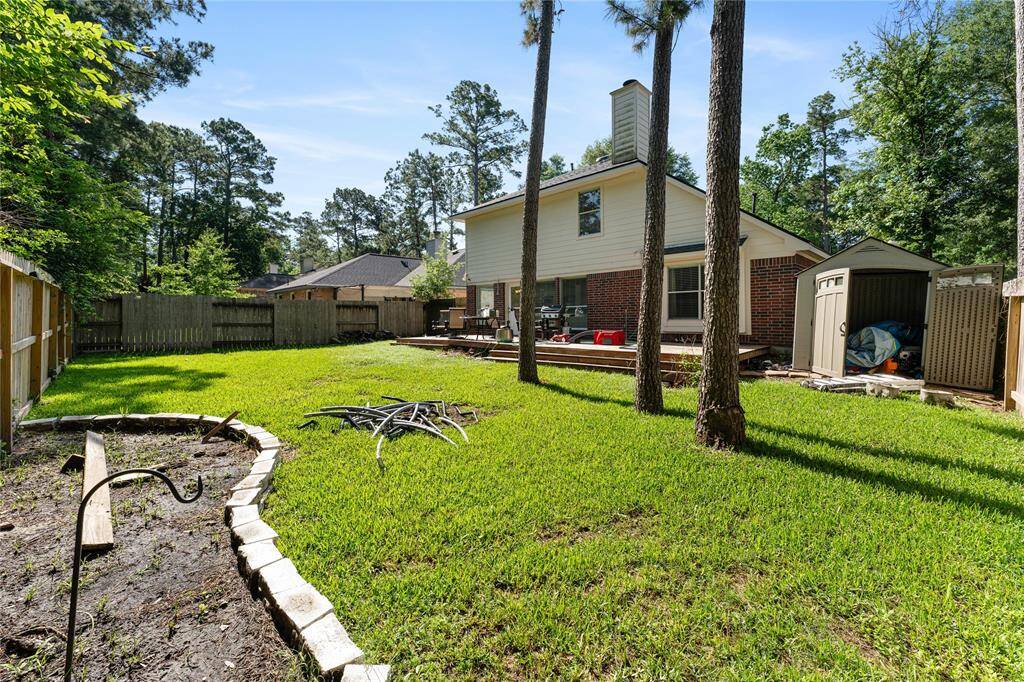 Two-story home with a spacious, fenced backyard featuring a wooden deck, perfect for outdoor entertaining. The yard is well-maintained with lush grass and mature trees, providing a serene and private setting.