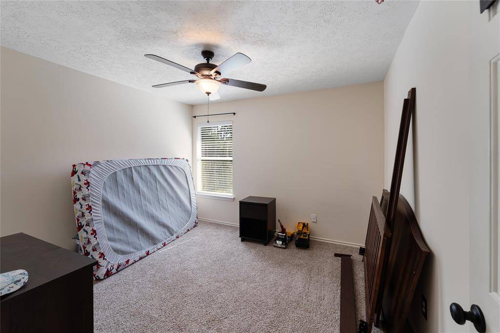 The room is carpeted, has a ceiling fan, and a window providing natural light.
