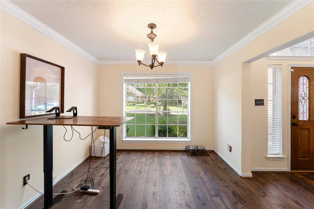 This photo showcases a charming two-story brick home with a spacious driveway and an attached garage. The front yard is well-maintained, featuring lush green grass and mature trees, providing ample shade and a welcoming atmosphere.