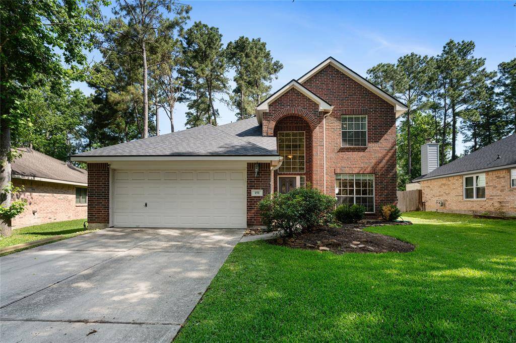 Charming entrance with a classic brick exterior, a welcoming front door, and large windows for natural light. The pathway is lined with rocks and greenery, adding to the curb appeal.