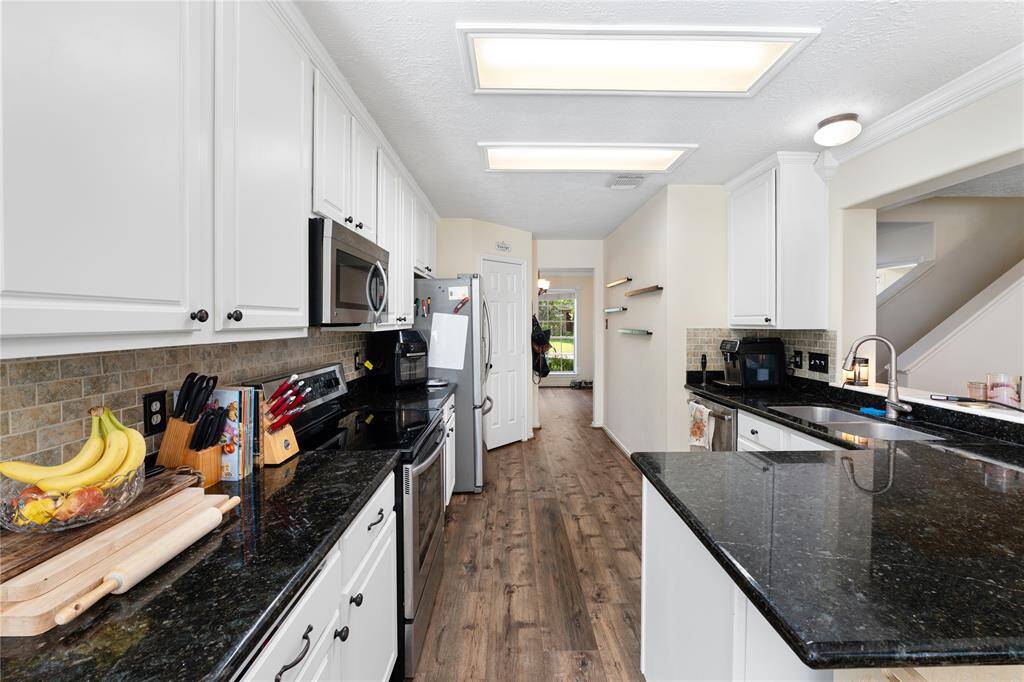 This bright room features large windows overlooking a green lawn, offering plenty of natural light. It has neutral walls, with a modern light fixture. Ideal for a home office or study space.