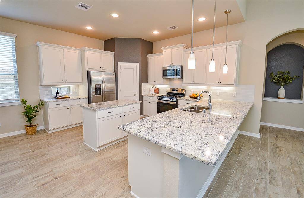 The heart of the home is this stunning, open-concept kitchen with modern white cabinetry and gorgeous granite countertops.