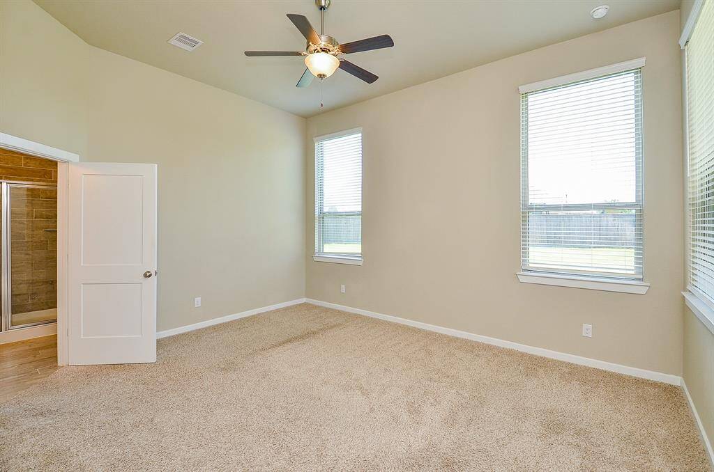 Retreat to your spacious primary suite, where comfort meets style. Plush carpeting and large windows create a cozy and light-filled atmosphere.