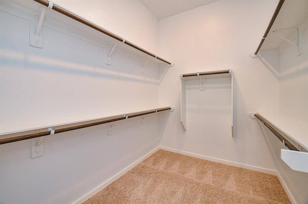 Say goodbye to clutter with this expansive walk-in closet designed with both function and flow in mind.