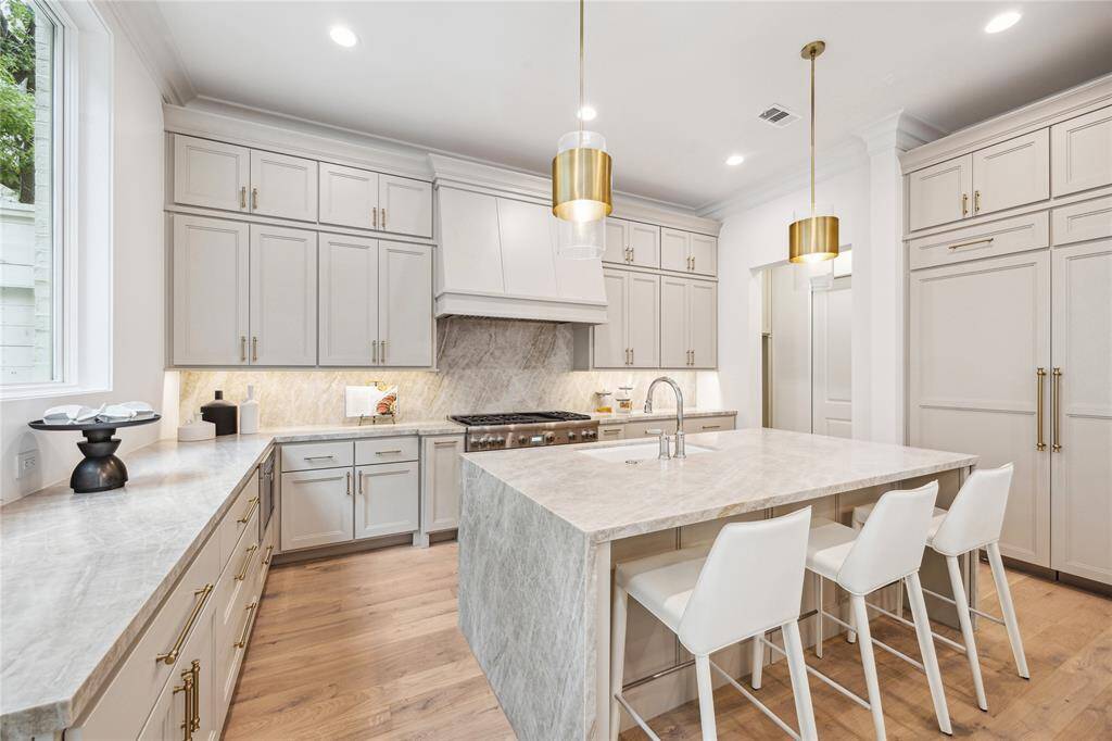 The kitchen showcases a premium Thermador appliance package, which includes a 48” Pro Harmony gas range, a 24” built-in MicroDrawer microwave, a 24” custom panel dishwasher, a 30” custom panel fresh food refrigerator, and 30” freezer columns.
