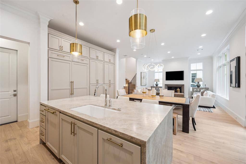 Leathered Taj Mahal Quartzite waterfall island and undermount Porcelain sink with Kallista faucet complete this luxury kitchen. Ample prep space, storage space, and island seating make this space functional and stunning.
