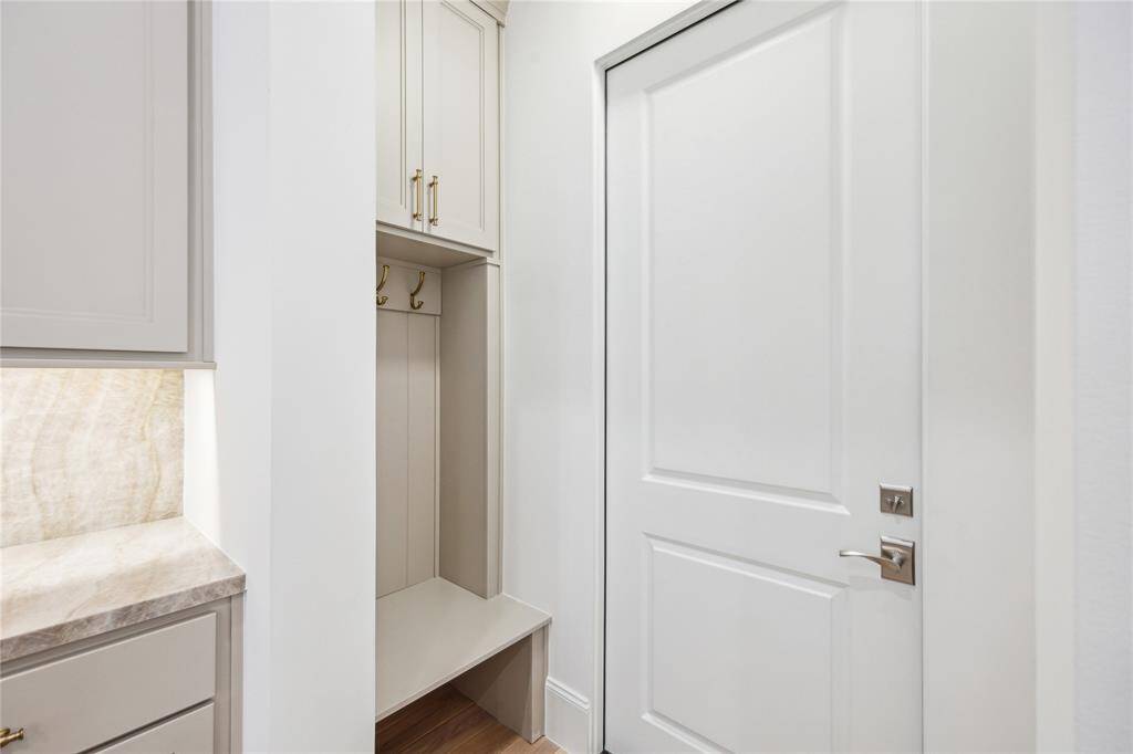 This drop zone can be found between garage and kitchen. With hooks, a bench, and storage cabinet, this space functions perfectly as a transition space.