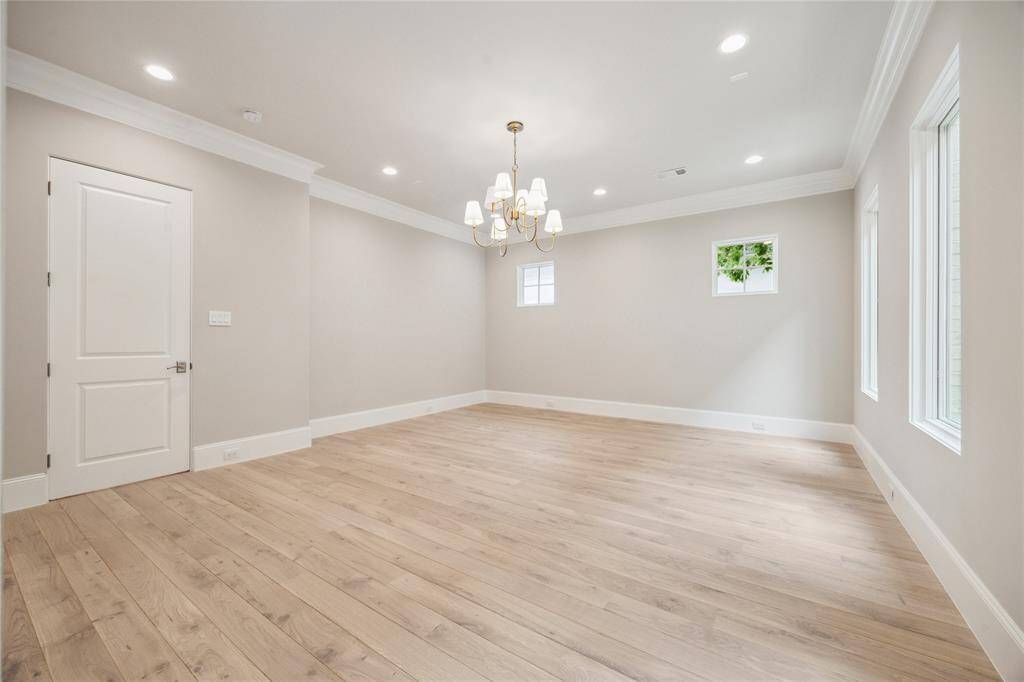 The primary suite is adorned with 10-foot ceilings and a designer light fixture. Exquisite Legno Bastone European White Oak wood floors continue in this space adding to its overall elegance and charm.