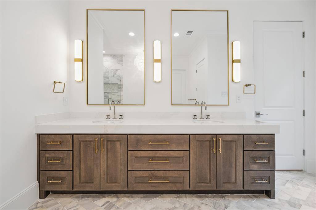 Custom Benedettini cabinetry, Quartzite countertops, Kallista Perfect under-mount oval sinks with Kallista One fixtures, and Alabaster sconces complete this elegant and serene primary retreat.
