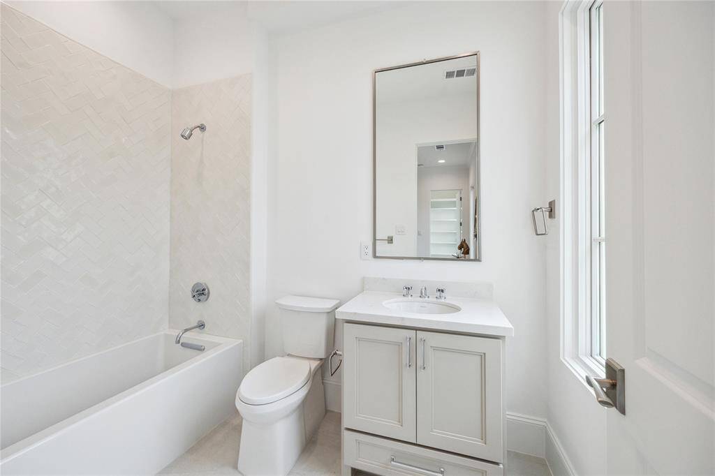 En-suite bath features Kohler Underscore alcove bath, Quartz countertops, and under-cabinet storage.