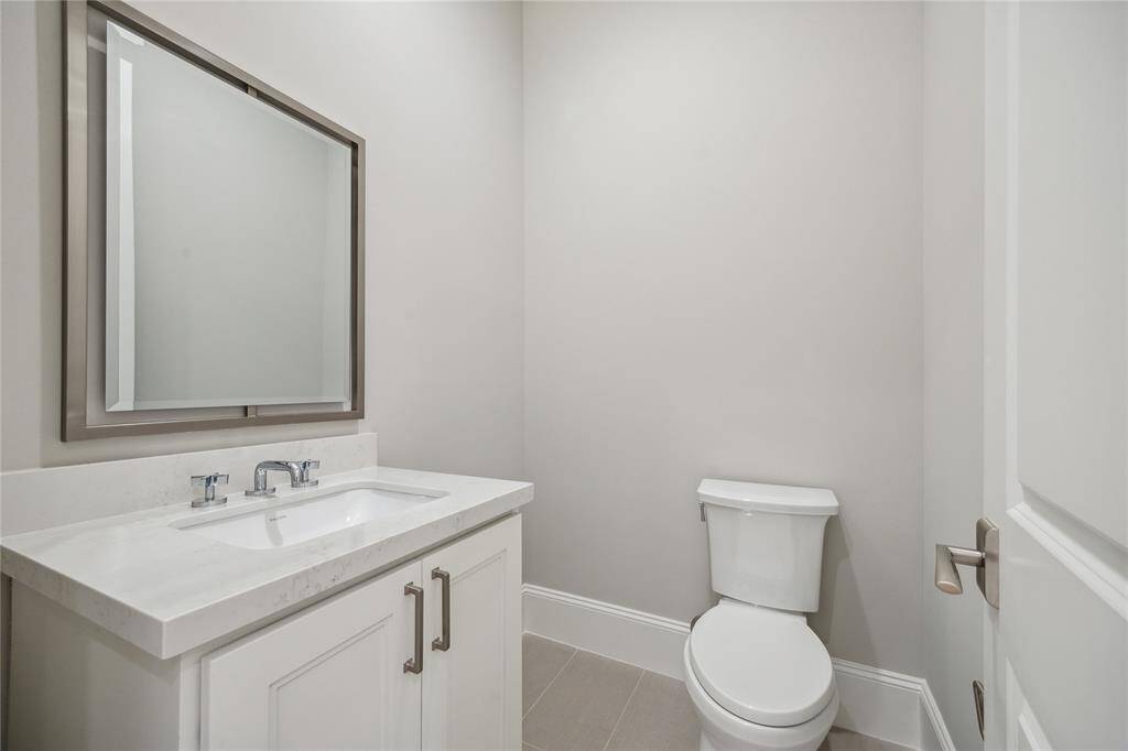 Conveniently located off of the third-floor flex space is a powder room featuring Biancone Quartz countertops.