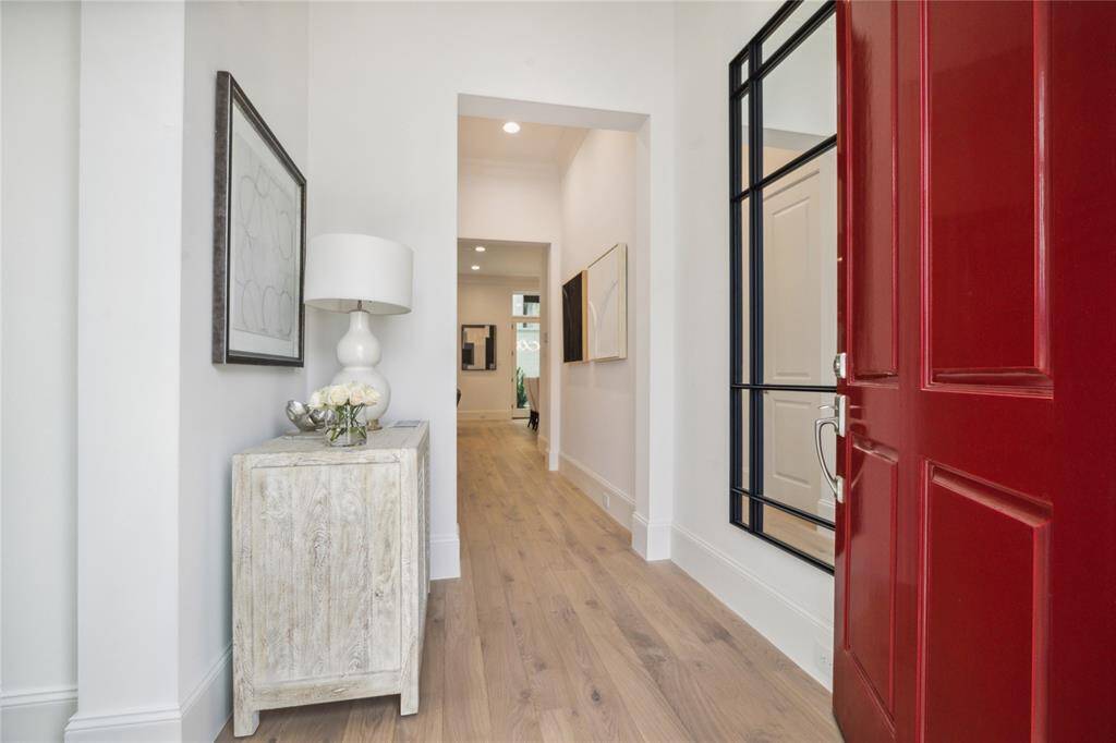 Step into this bright and welcoming formal entry. The first floor living space features 11-foot ceilings, Legno Bastone engineered White Oak wood floors, and designer light fixtures.