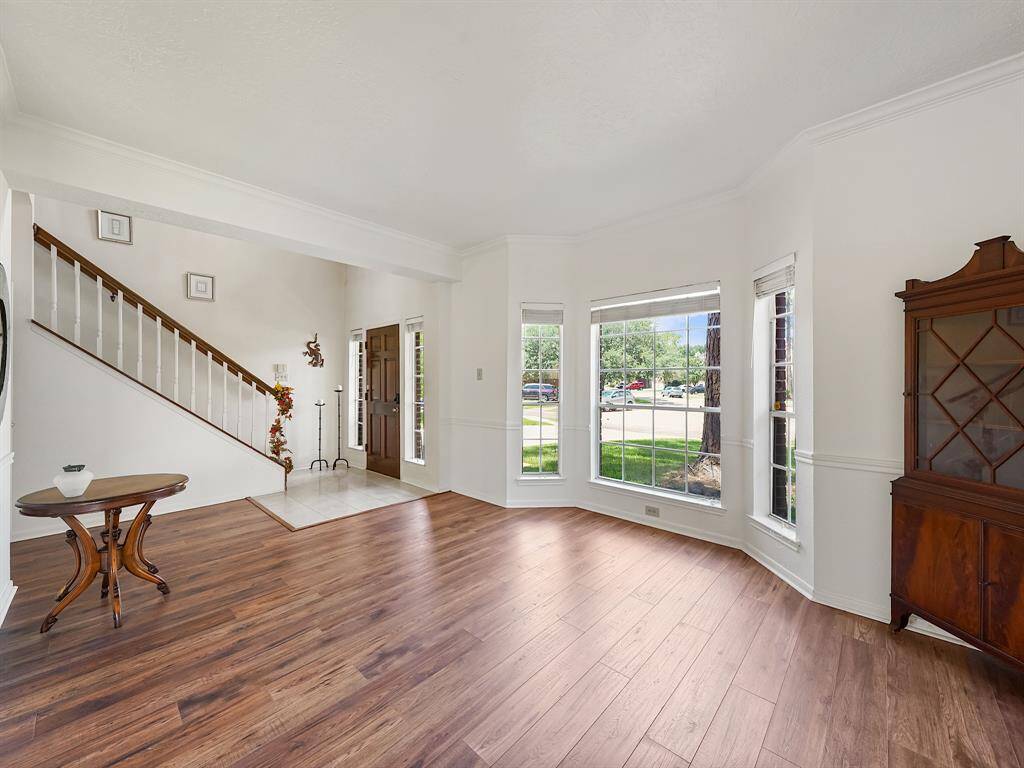 Step into this inviting entryway, where natural light pours in to highlight the warm tones of the floors.