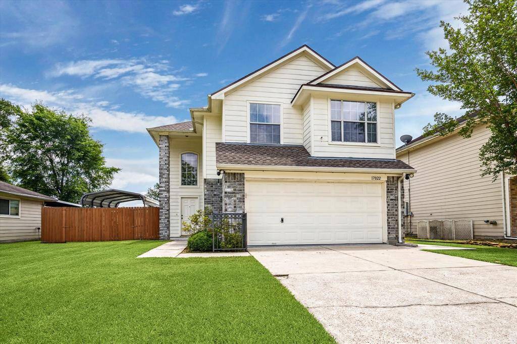 This two-story home features a modern exterior with a combination of brick and siding, a spacious two-car garage, and a neatly maintained front lawn.