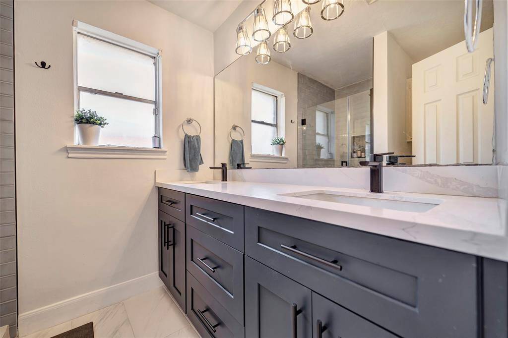 The primary en-suite bathroom has been recently updated and features custom cabinetry and double sinks.