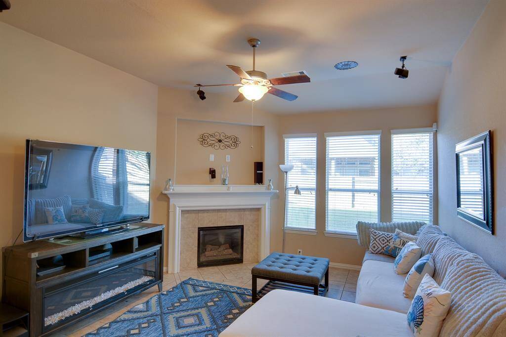 The expansive living room offers modern, open-concept design filled with natural lights from large windows. The soaring ceilings, enhance the spacious feel, while the neutral tones and fireplace invite relaxation. Ideal for both everyday comfort and stylish gatherings, this space exudes luxury and warmth.