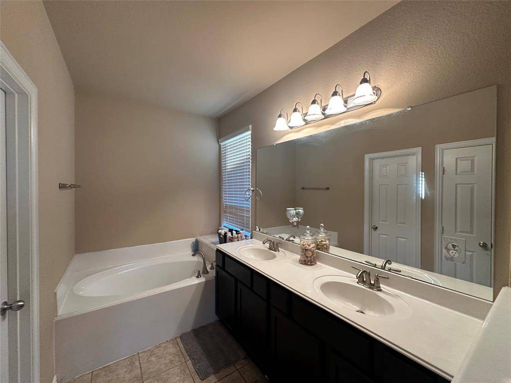 Grab the bubble bath, put on some music, and enjoy a wonderful evening in your amazing spa like garden bath soaking tub! Featuring tile flooring, neutral paint and double sinks.