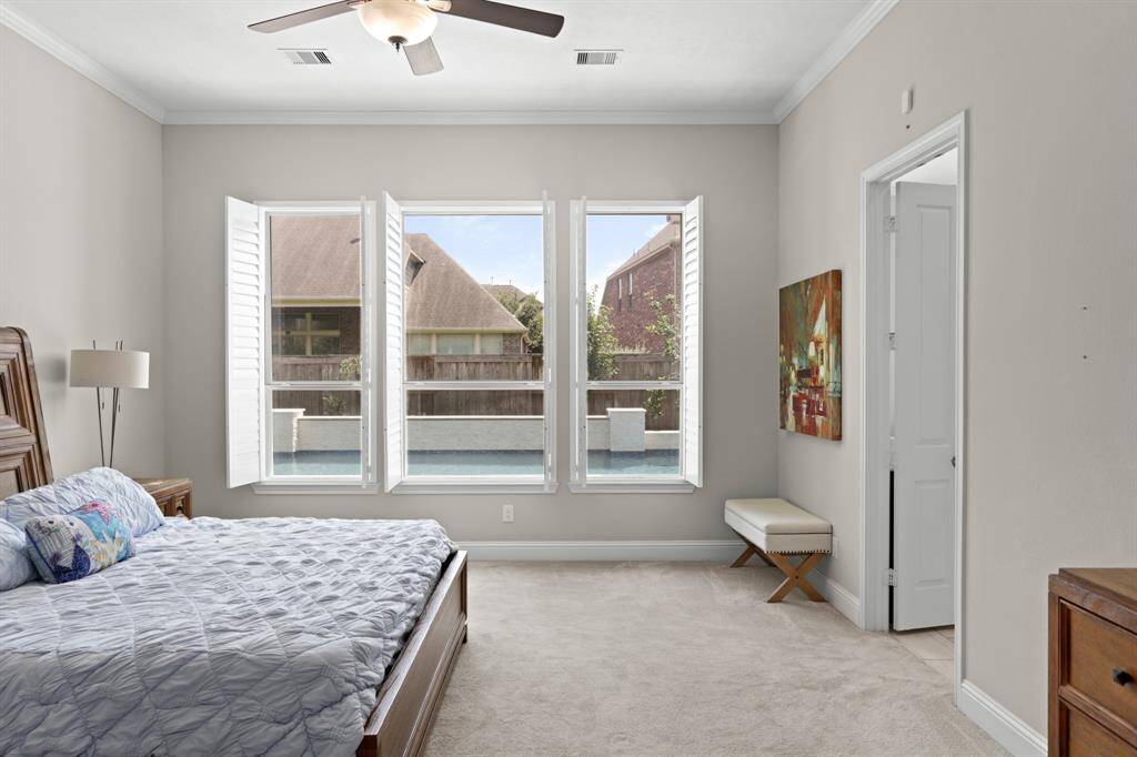 Primary bedroom located on the first floor with en-suite bath and views of the backyard.