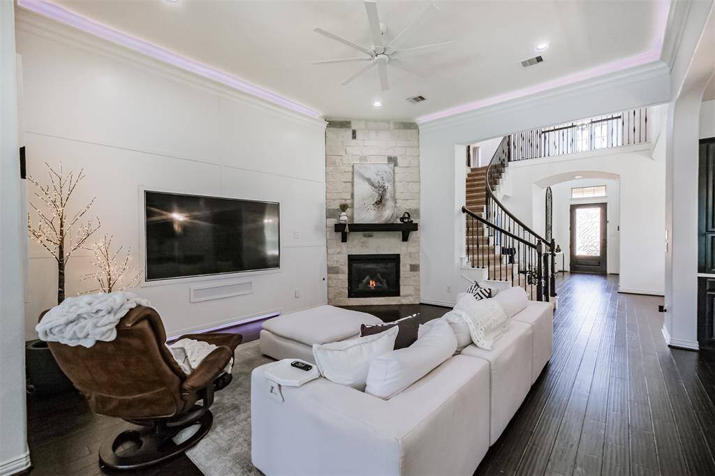 Hardwood floors and accent wall with backlit LED interchangeable lighting add a unique feature to this Living Room.