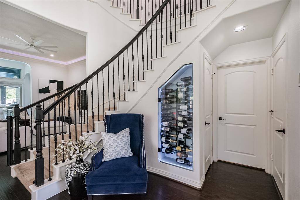 Winding staircase creates the perfect spot for a glass enclosed wine storage with LED lighting and temperature control.