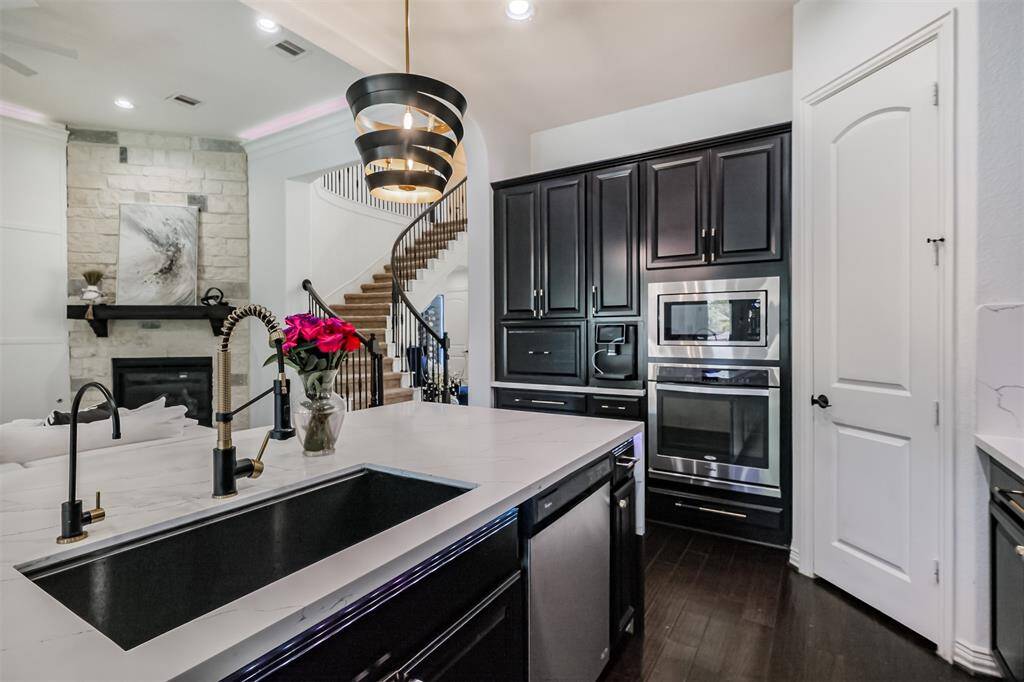 View of sink, dishwasher, oven and microwave--look at the beautiful semi-pro faucet and water dispenser in matte gold and black!