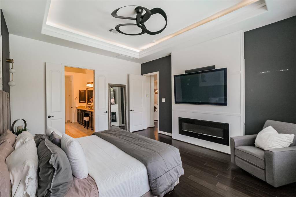 Accent wall with built ins, tray ceiling, backlit LED lights and amazing ceiling fan.
