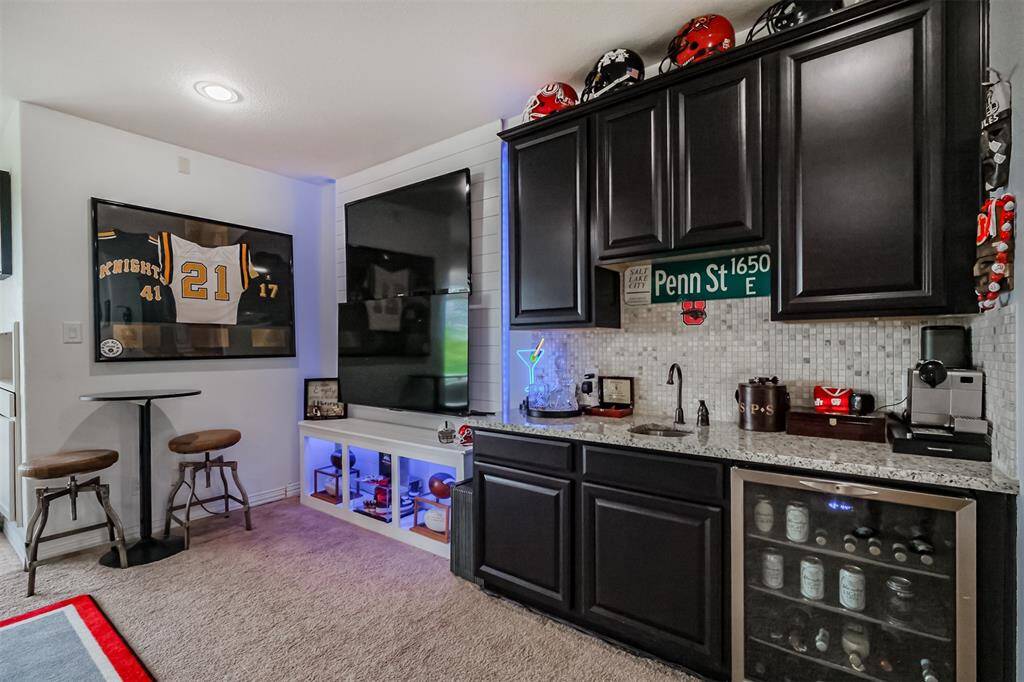 Upstairs Game Room has so many unique features--Accent wall with two TVs, built in display case with LED lighting, Wet bar with granite counter, sink and beverage refrigerator.