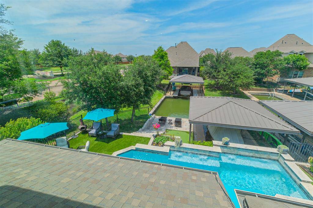 View from the Office/Study of the backyard pool, boat house and lake.