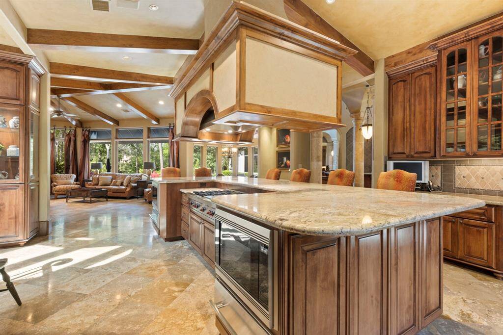 The kitchen seamlessly flows into the family and breakfast rooms, creating an open-concept space that fosters easy conversation and effortless entertaining.