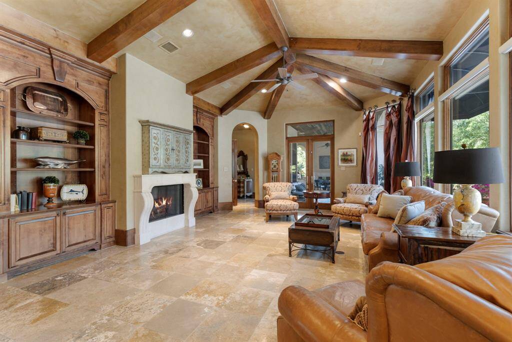 Eye-catching vaulted ceilings, exposed beam accents, and an abundance of windows enhance the home's warmth and inviting ambiance.