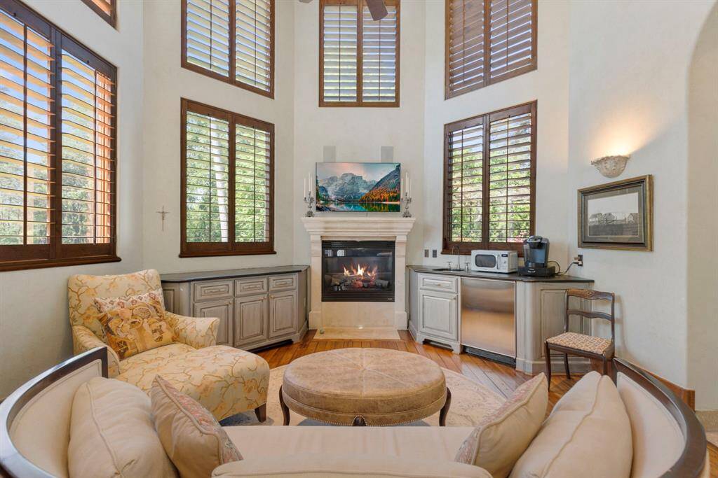 The primary retreat includes a cozy sitting area with a charming fireplace, along with a convenient coffee bar complete with a fridge and sink.