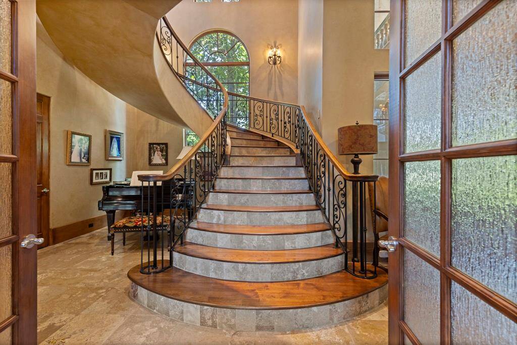Directly across the formal library, one of two staircases leads the way to the second floor living spaces.