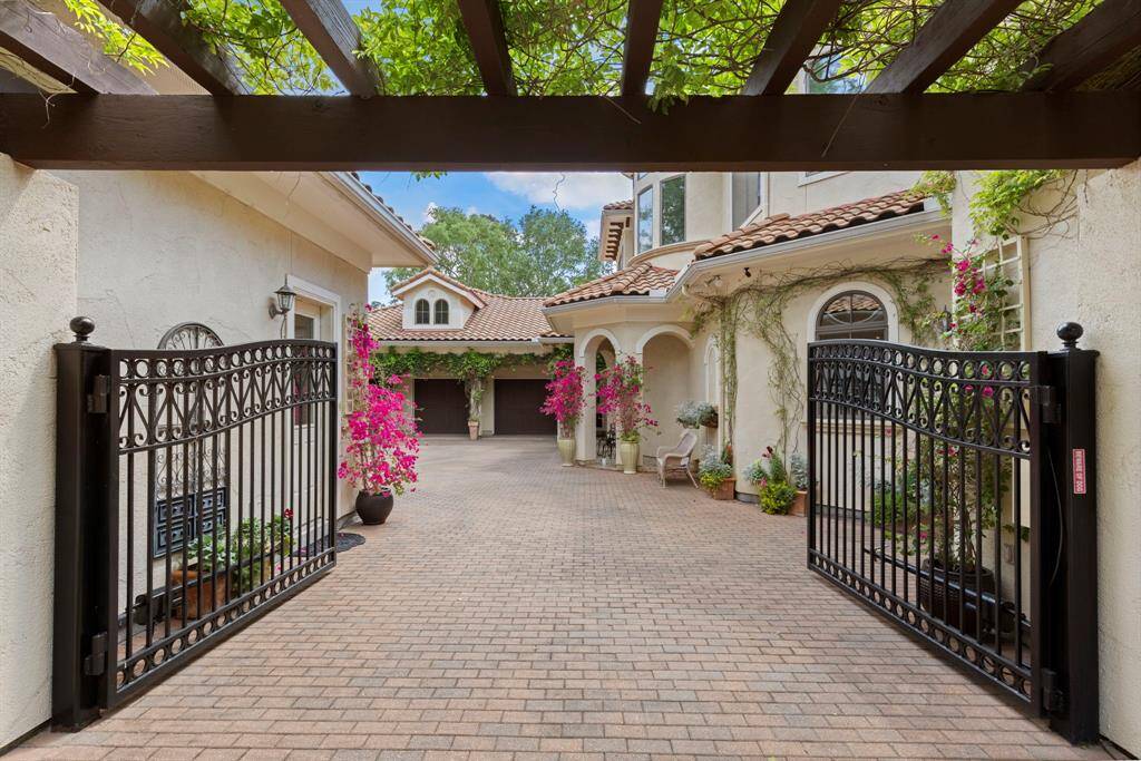Double gated entry and charming wood trellis open to the motor court.