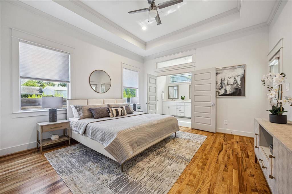 Serene primary suite with tray ceilings, abundant natural light, and direct access to the ensuite bath - your perfect retreat at the end of the day.