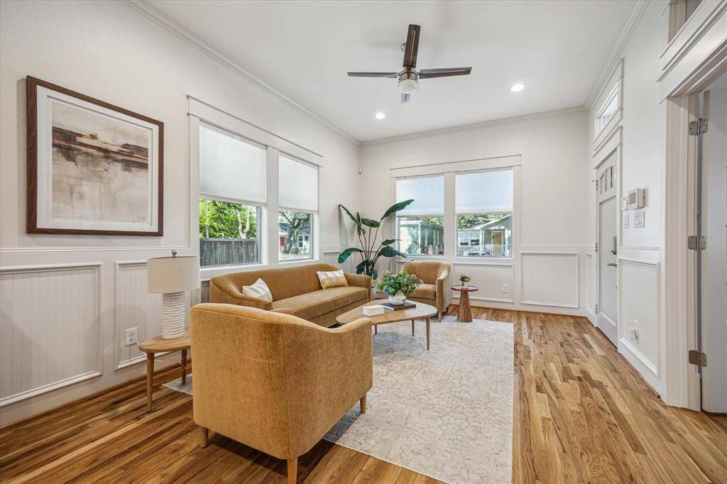 Sunlit front living room with two large windows overlooking oak-lined Tabor Street