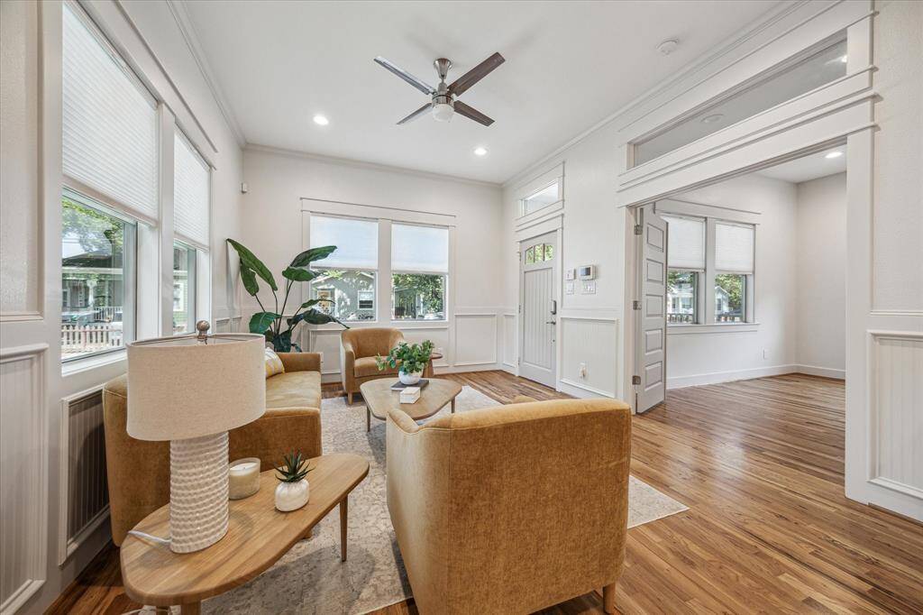 A set of double doors leads from the living room into the first bedroom/office, with transom windows and wide openings that enhance light and flow.